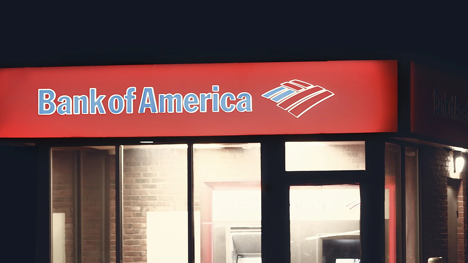 Illuminated Bank of America ATM structure against a dark nighttime backdrop in Boston